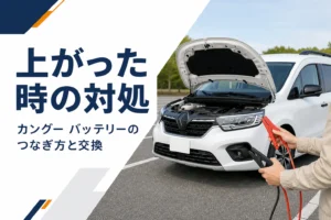 ボンネットを開けた小型MPVとブースターケーブルを手にした手元のイメージ